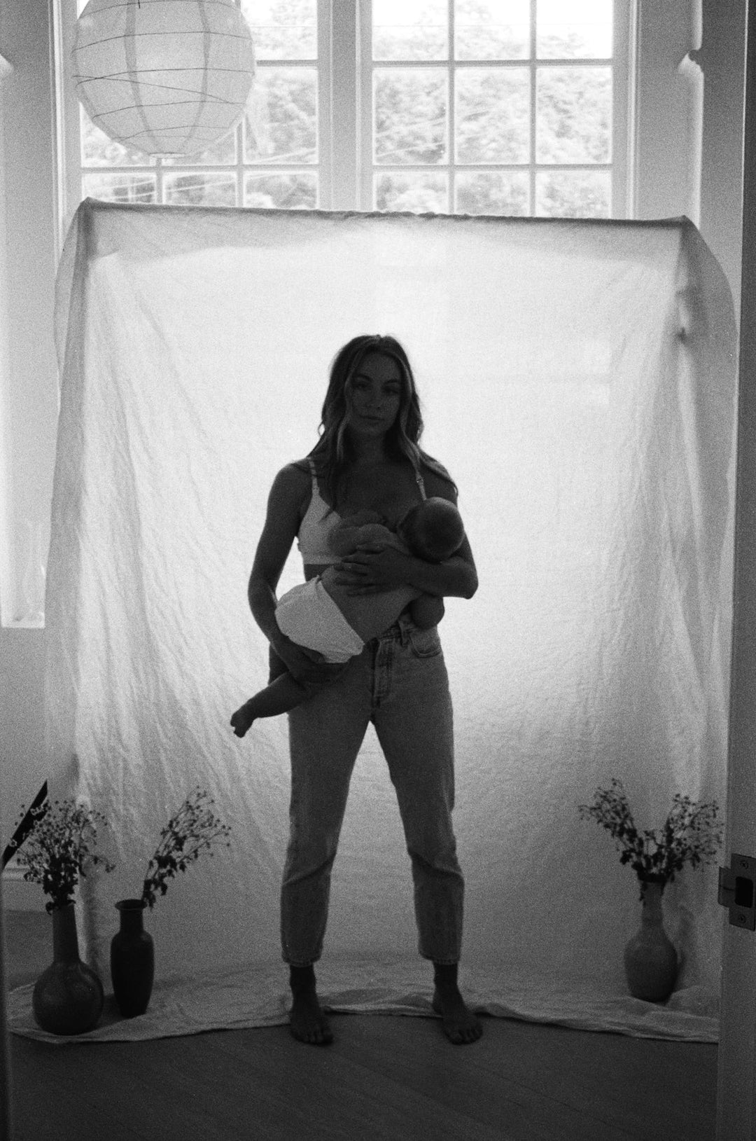 Bel White is sat in a birth pool cradling her new baby, moments hold. She is leant over kissing her husband in joy. 